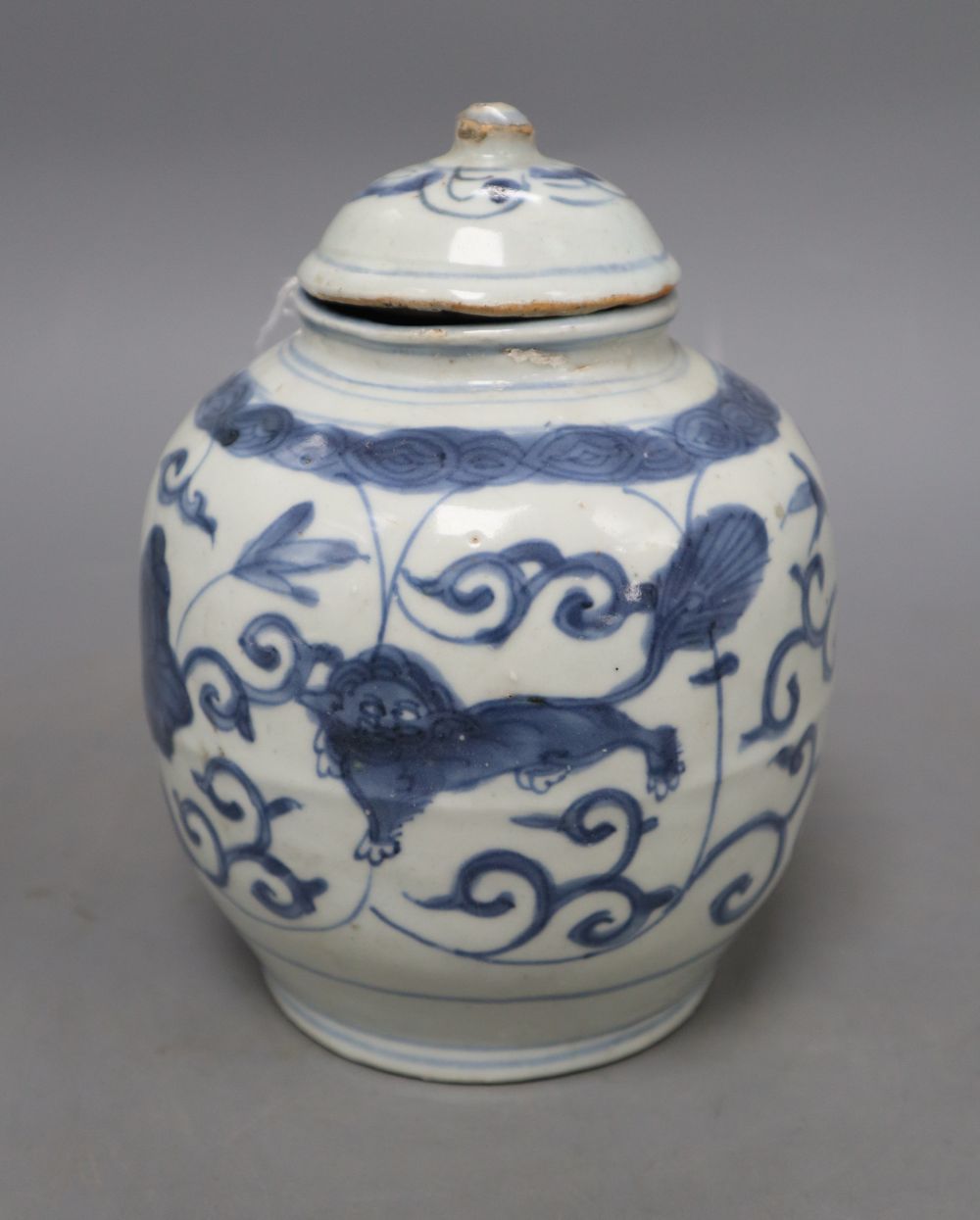 A Chinese Late Ming blue and white lion and lotus jar and cover, overall height 17.5cm, restored rim